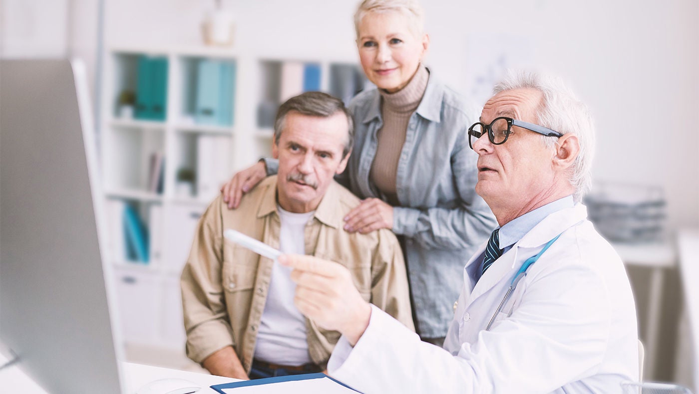 Dokter legt een koppel prostaatkankercondities uit en toont die op een computerscherm.