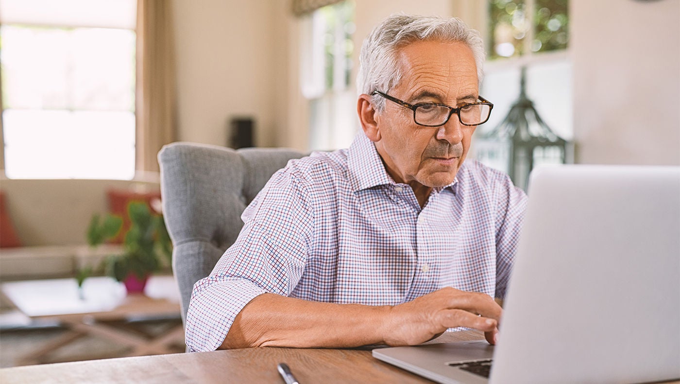 Een man zoekt urologische aandoeningen op zijn laptop.