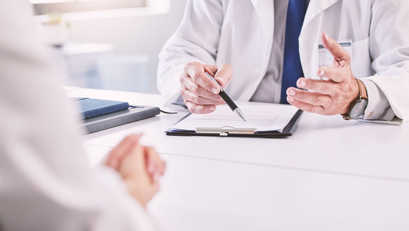 Doctor with notepad talking to patient about hydrogel spacer