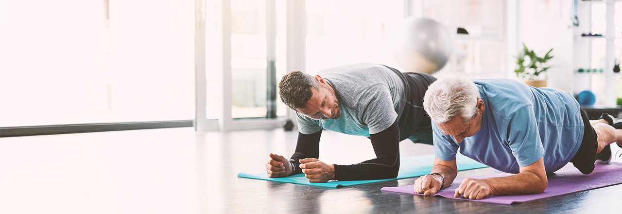 Twee mannen die aan yoga doen en praten over goedaardige prostaatvergroting.