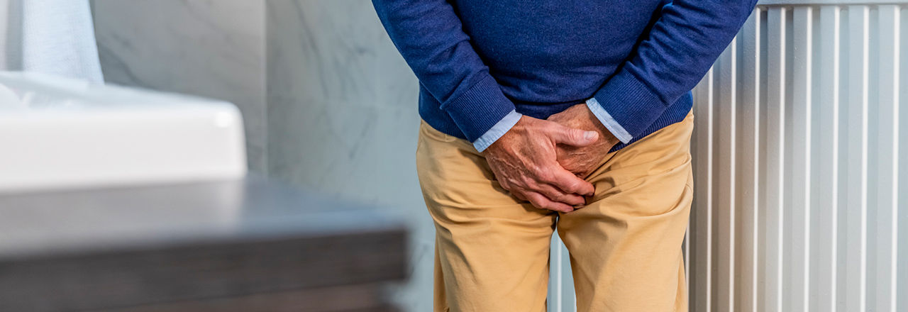 Man heeft last van plasstress als gevolg van mannelijke incontinentie.