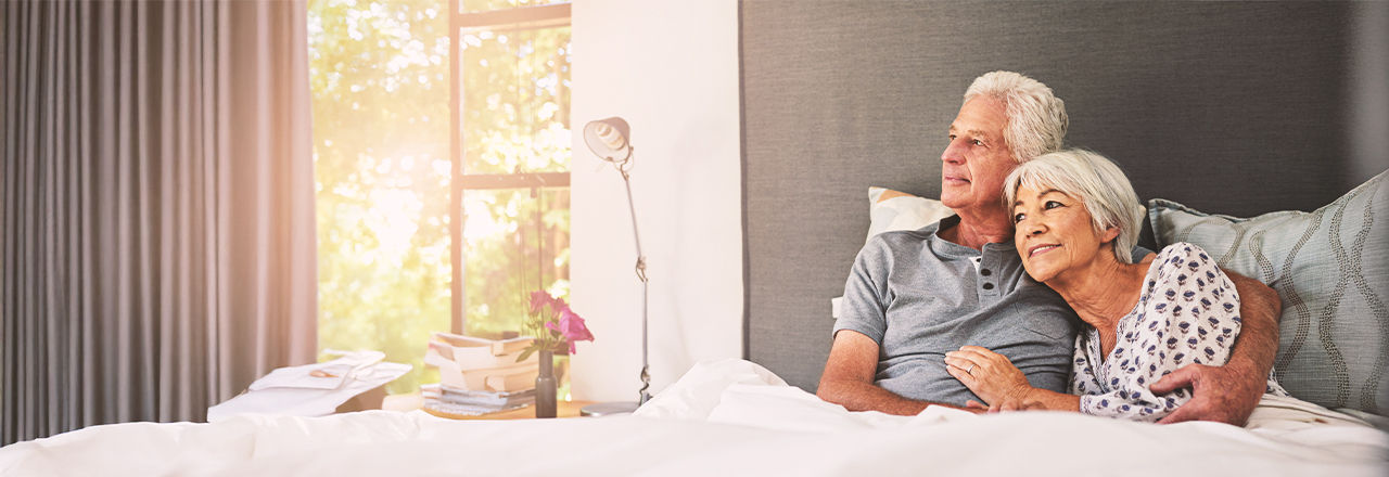 Man met een penisinplant ligt in bed naast zijn vrouw.