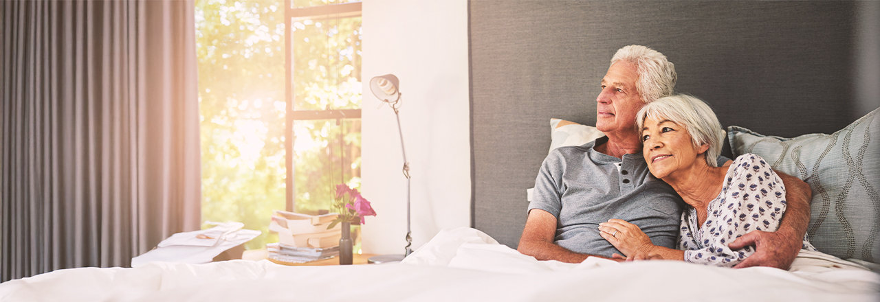 Man met een penisinplant ligt in bed naast zijn vrouw.