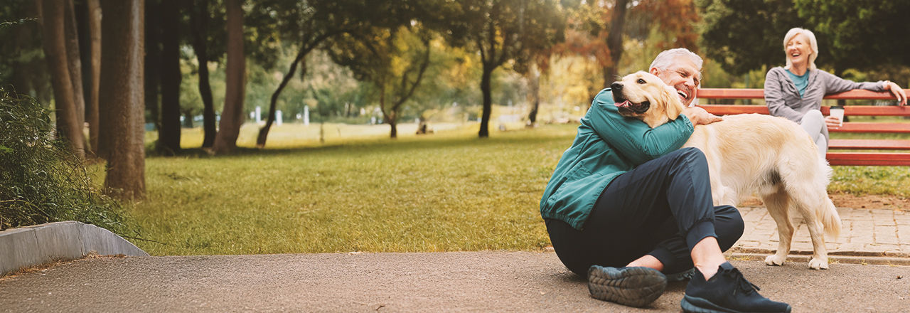 Man herstelt van kankerbehandeling en speelt met een hond.
