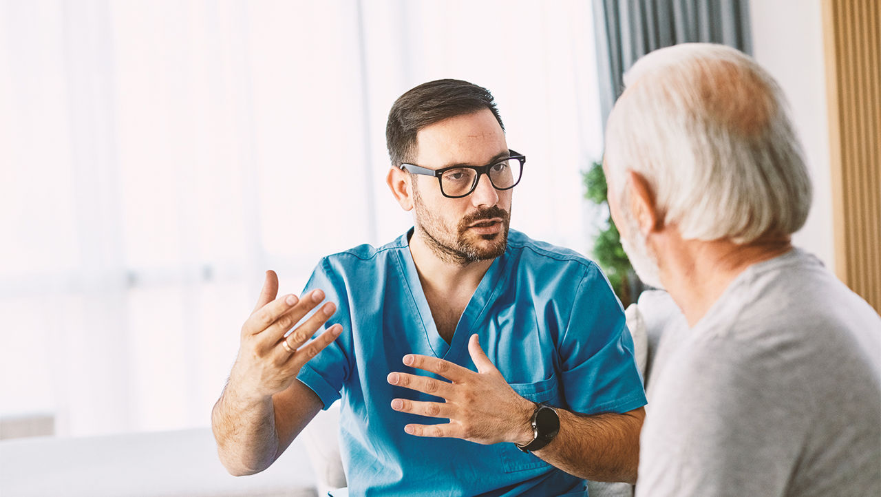 Man praat met dokter over mannelijke incontinentie.