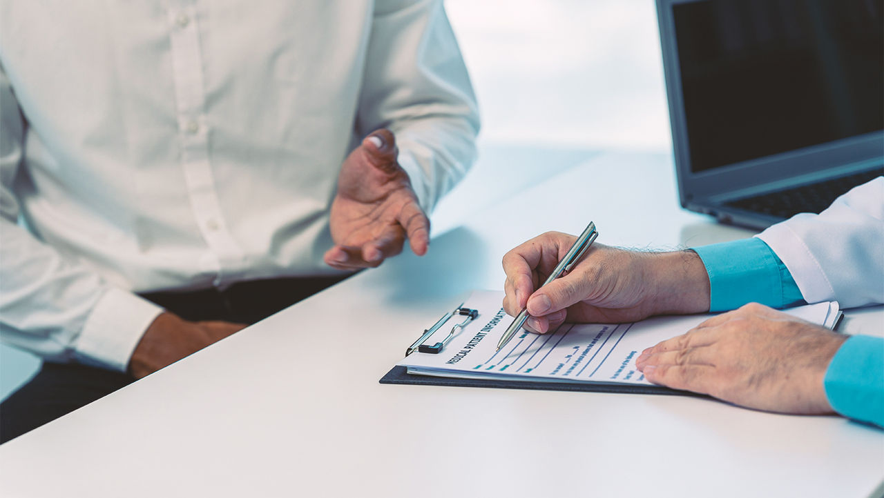 Man praat met dokter over male slingsysteem.