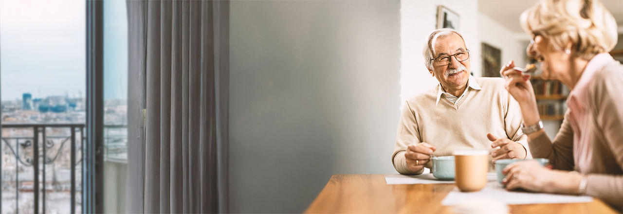 Man met een male slingsysteem en vrouw eten ontbijt.