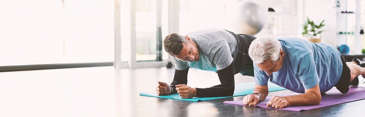 Two men doing yoga, talking about benign prostate enlargement