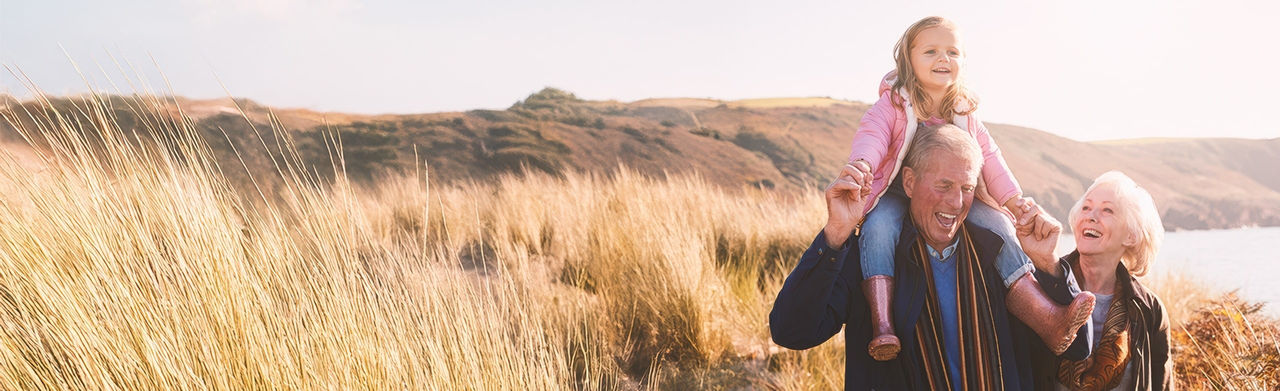 Elder couple with granddaughter in a field, the grandfather suffers from prostate cancer