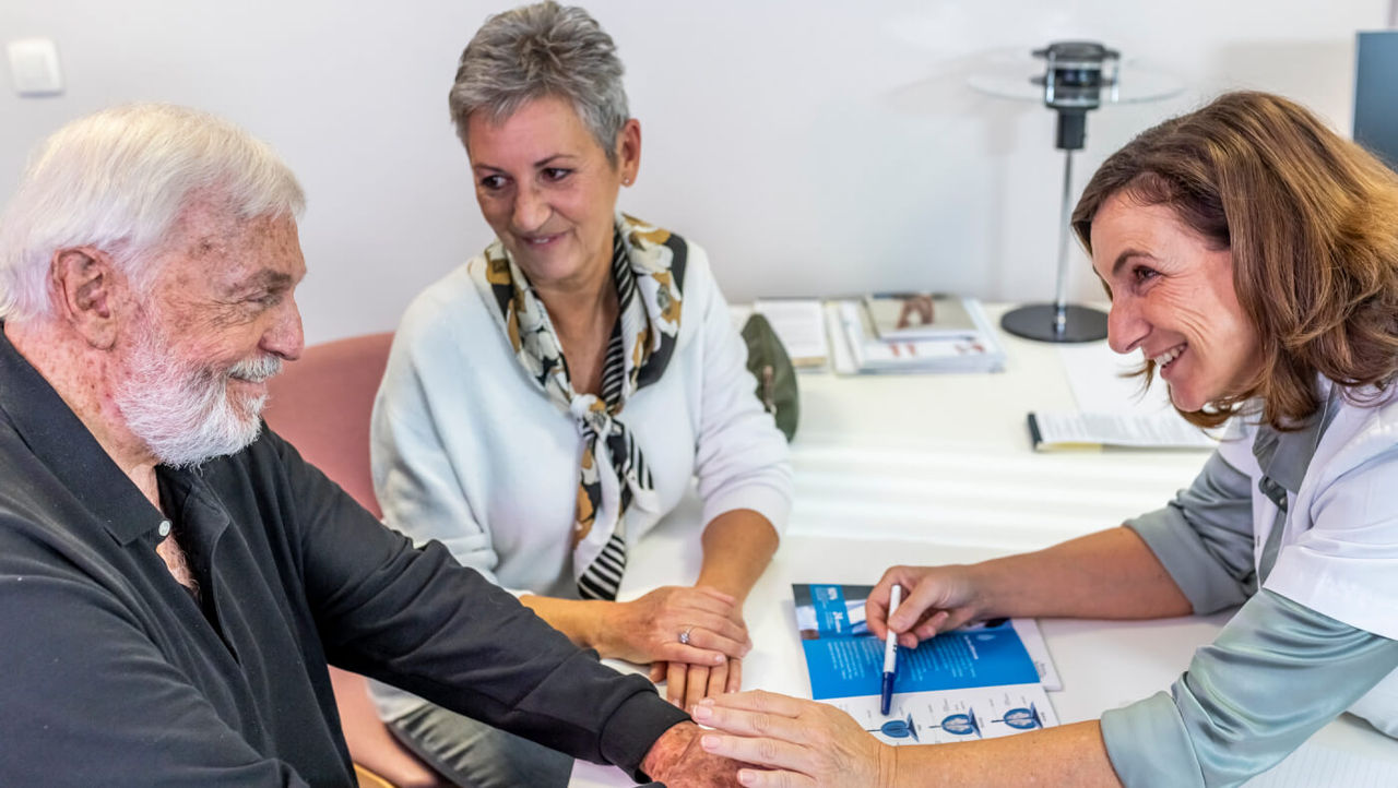 A doctor reassuring a male patient and his partner