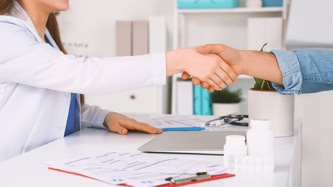 A doctor reassuring a male patient and his partner