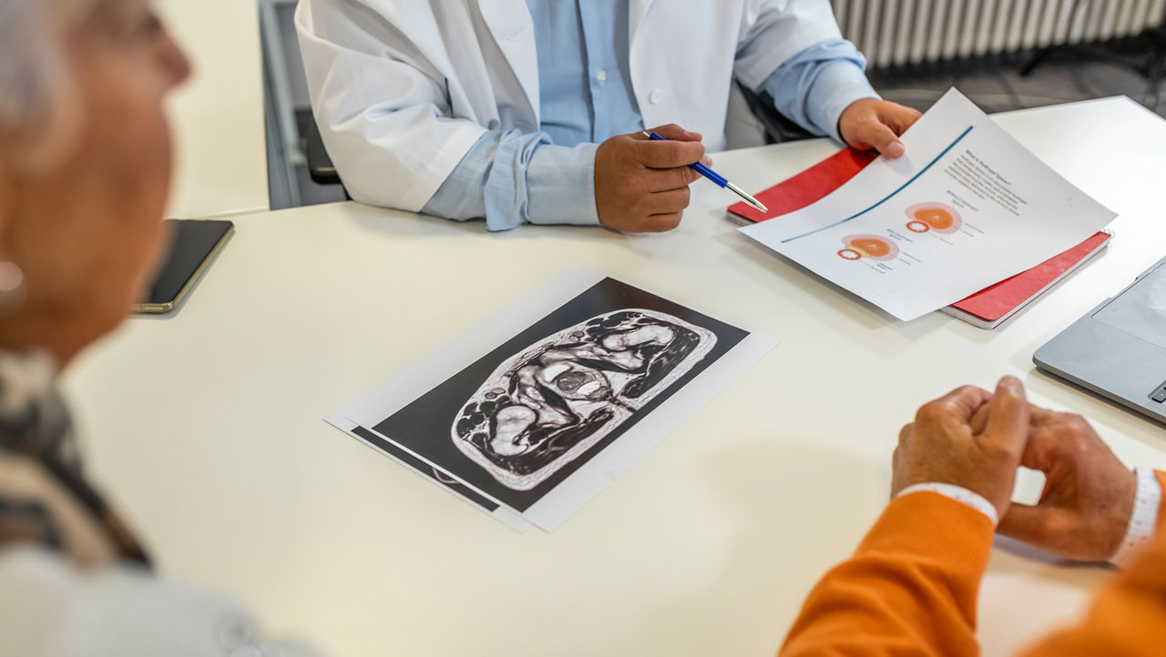 Läkare som förklarar urininkontinens för äldre patienter.