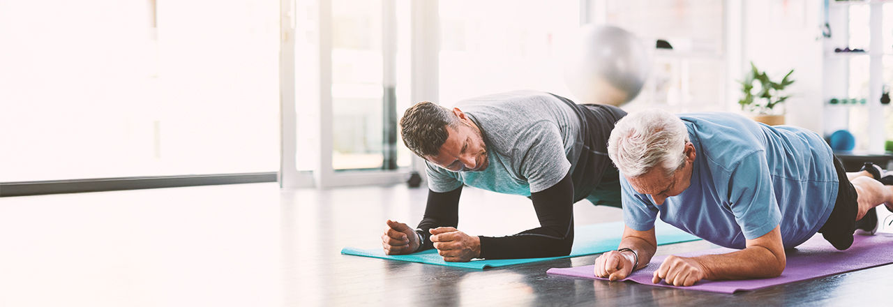 Två män gör yoga och pratar om godartad prostataförstoring.