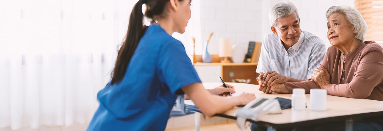 Older couple talking to doctor about treatment options