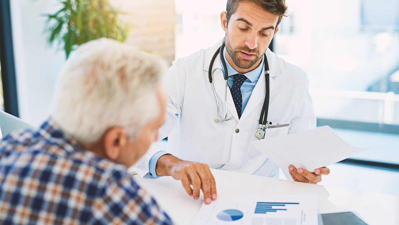 Doctor showing statistic documents about laser treatment to a male patient