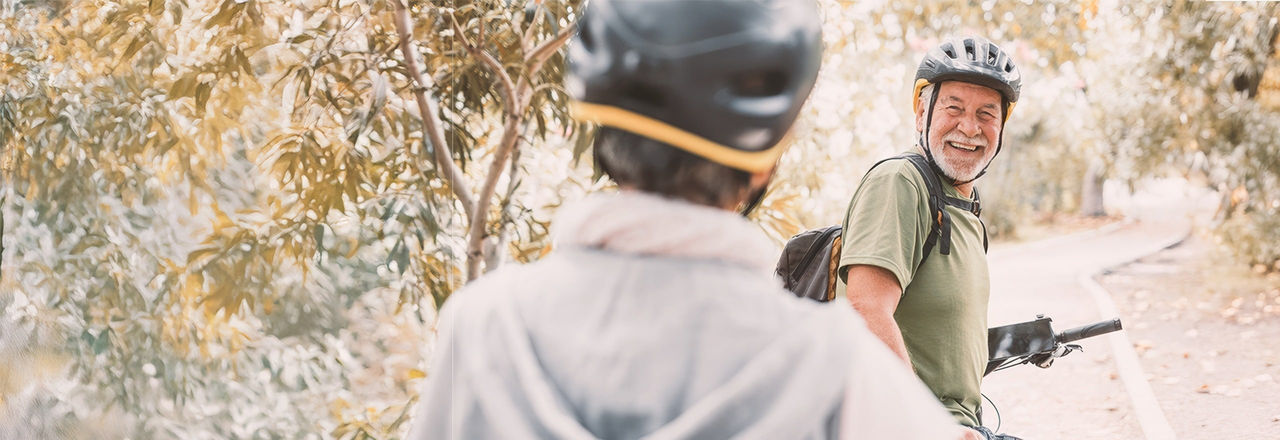 An older woman embraces her male partner from behind