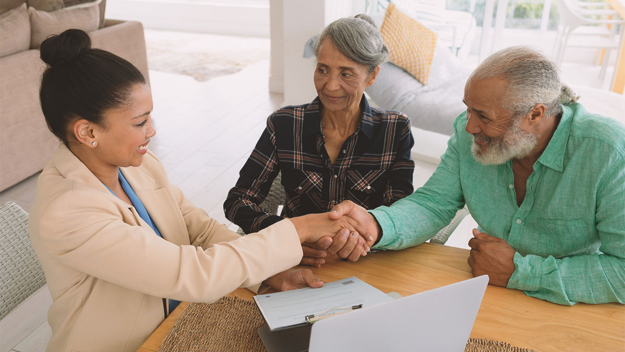 Doctor and couple shaking hands after talking about artificial urinary sphincter