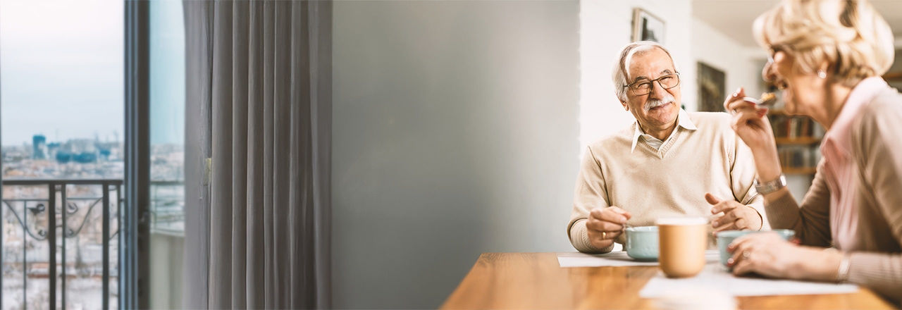 Man with male sling system and wife eating breakfast